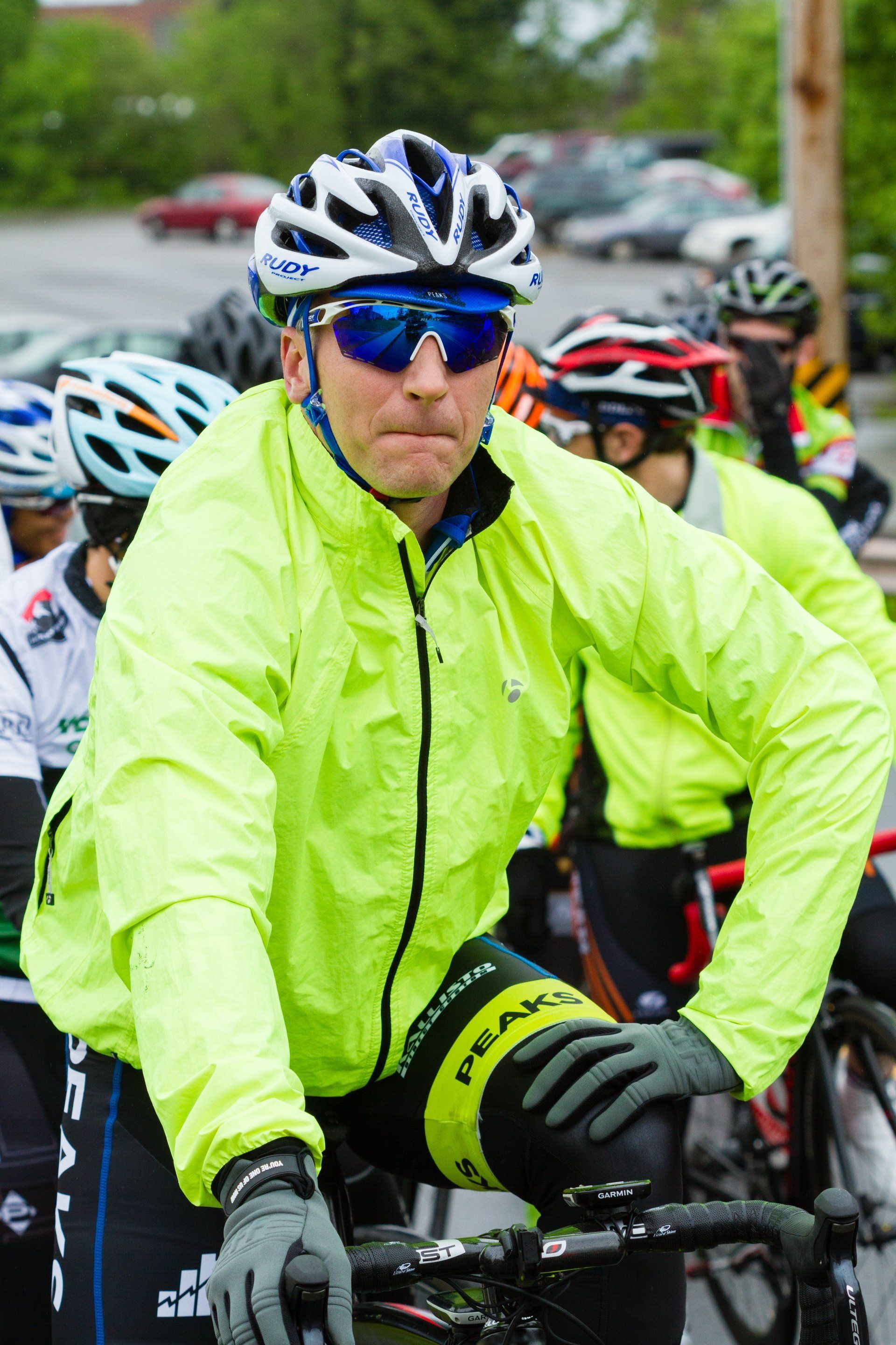 A man wearing a helmet and sunglasses is riding a bike