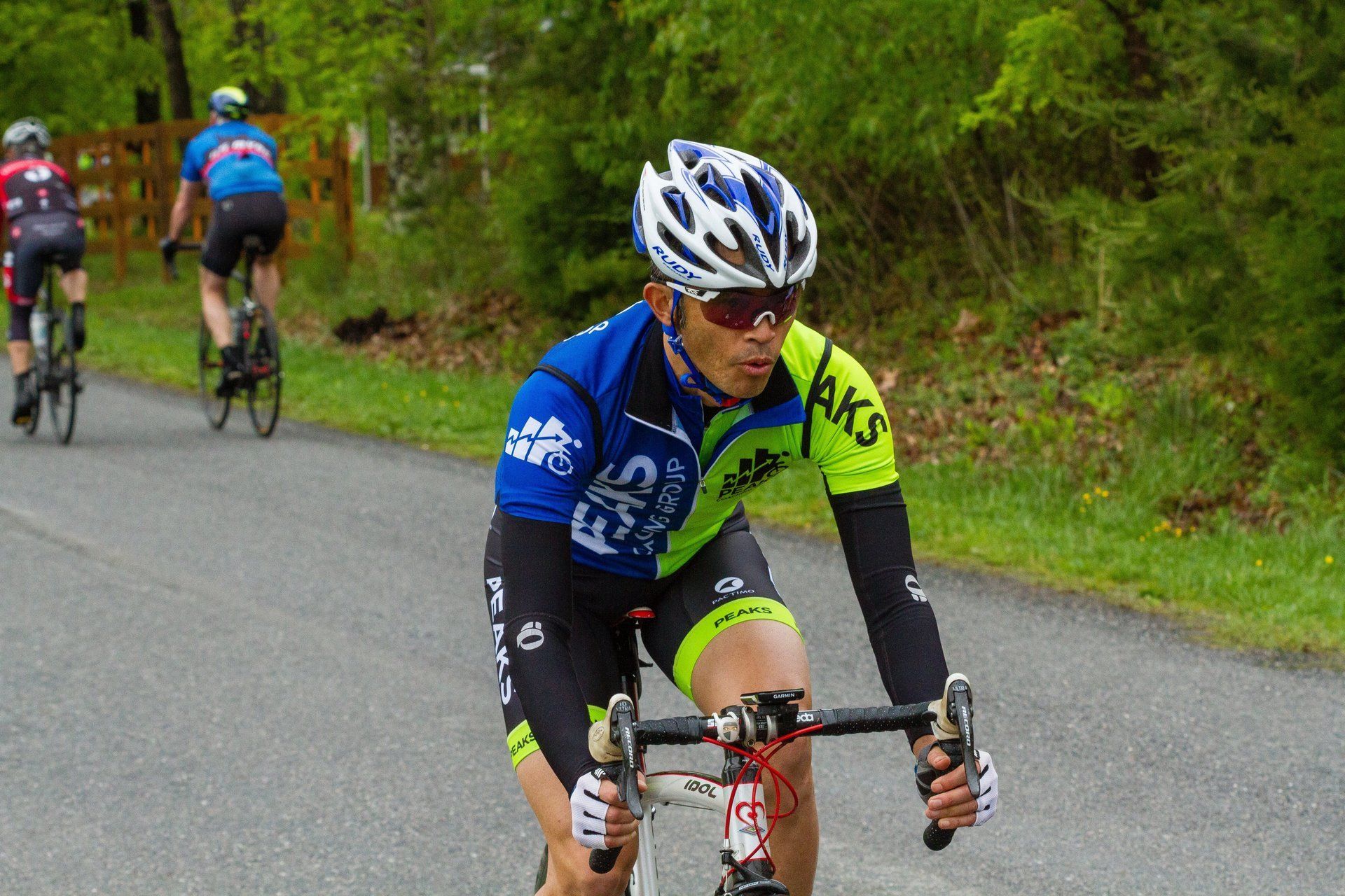 A man wearing a helmet is riding a bike down a road.