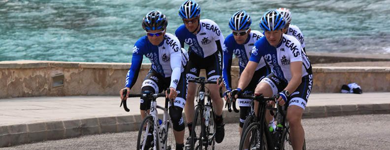 A group of men are riding bicycles down a street.