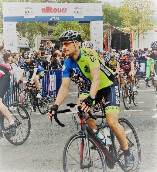 A man riding a bike with the word peuk 's on his shirt