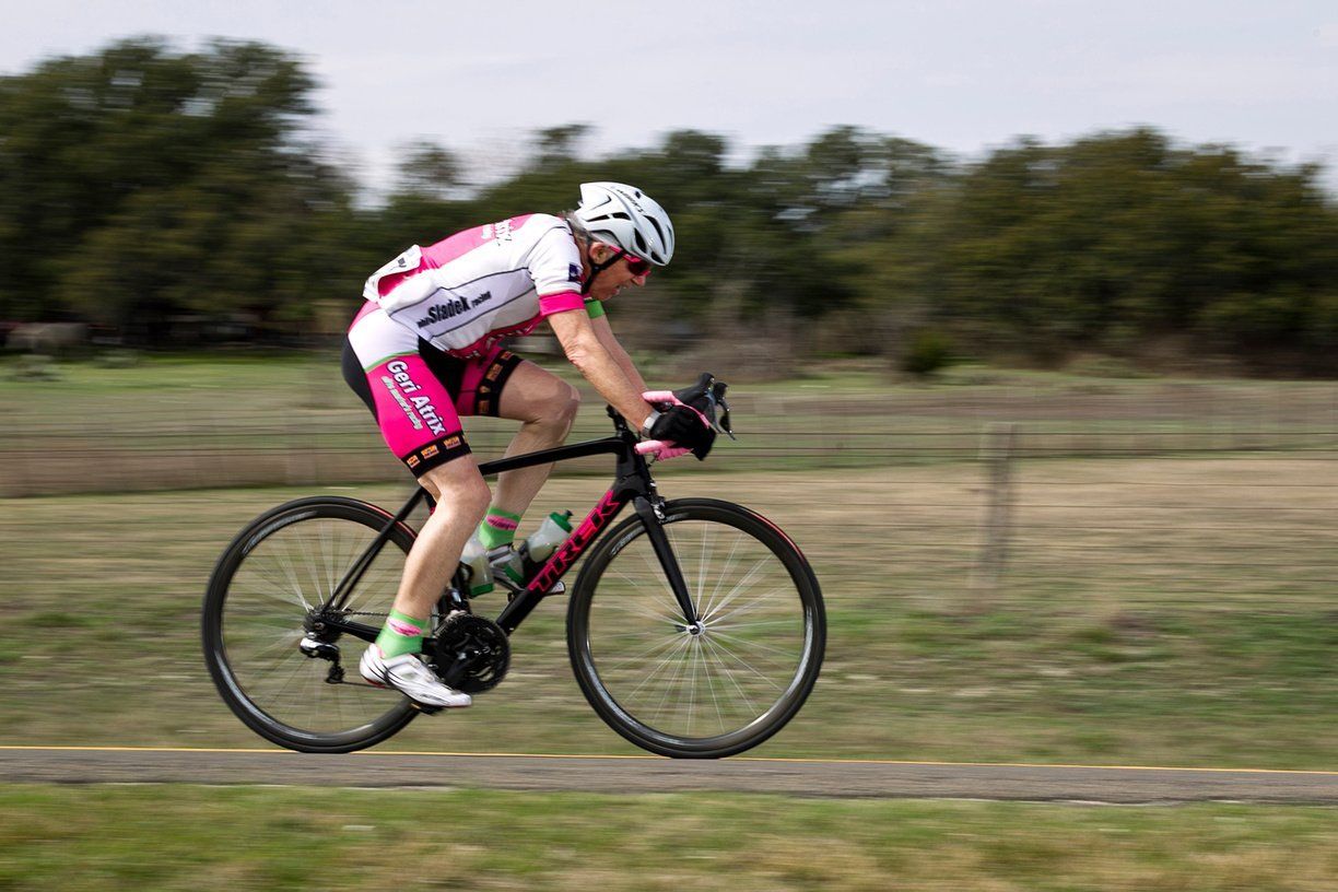A person is riding a bike on a path in a field.