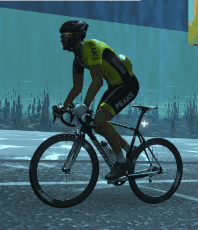 A man is riding a bike with the word peaks on his jersey