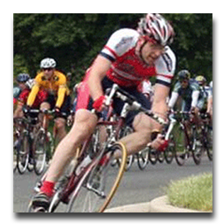 A group of cyclists are riding down a road.