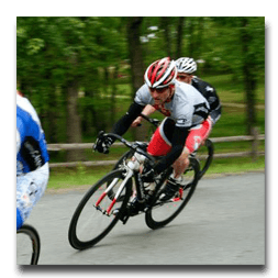 A man wearing a helmet is riding a bike down a road.