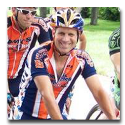 A man wearing a helmet and sunglasses is riding a bike.