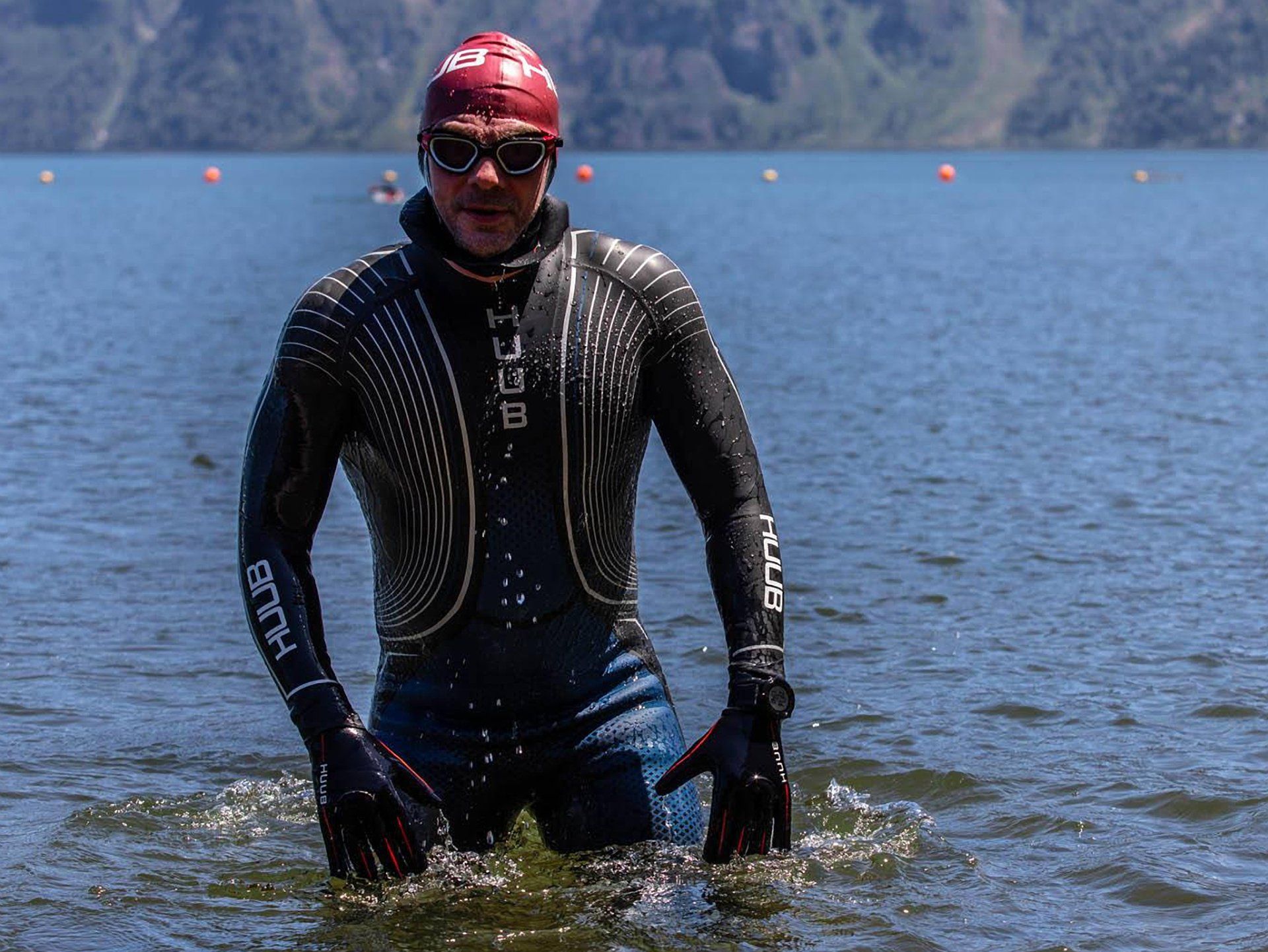A man in a wet suit is standing in the water