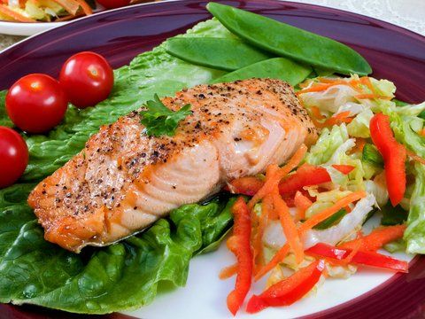 A plate of food with salmon and vegetables on it
