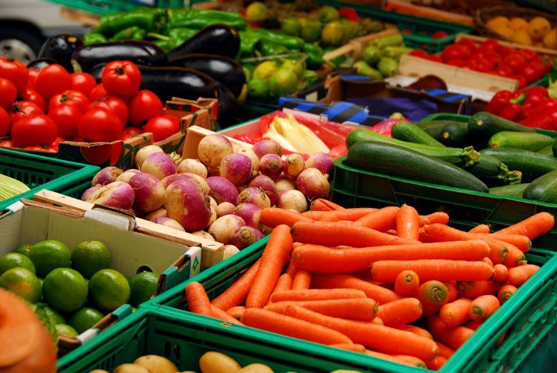 A variety of fruits and vegetables are on display at a market.