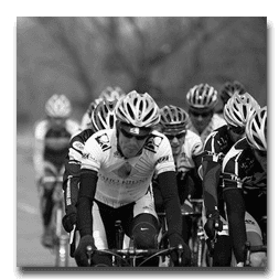 A group of cyclists are riding down a road.