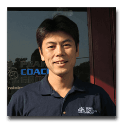 A man wearing a blue shirt with the word coach on it