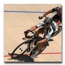 A man wearing a helmet is riding a bike on a track