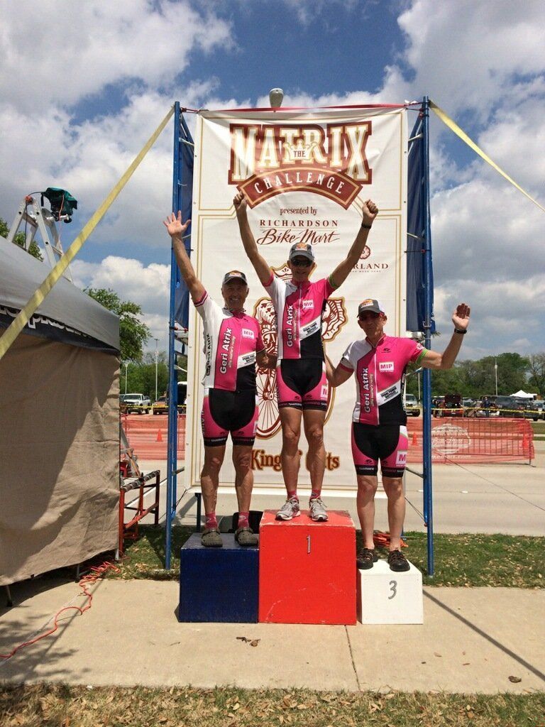 Three people standing on a podium in front of a sign that says matrix