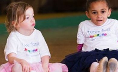 Two small kids sitting on the floor