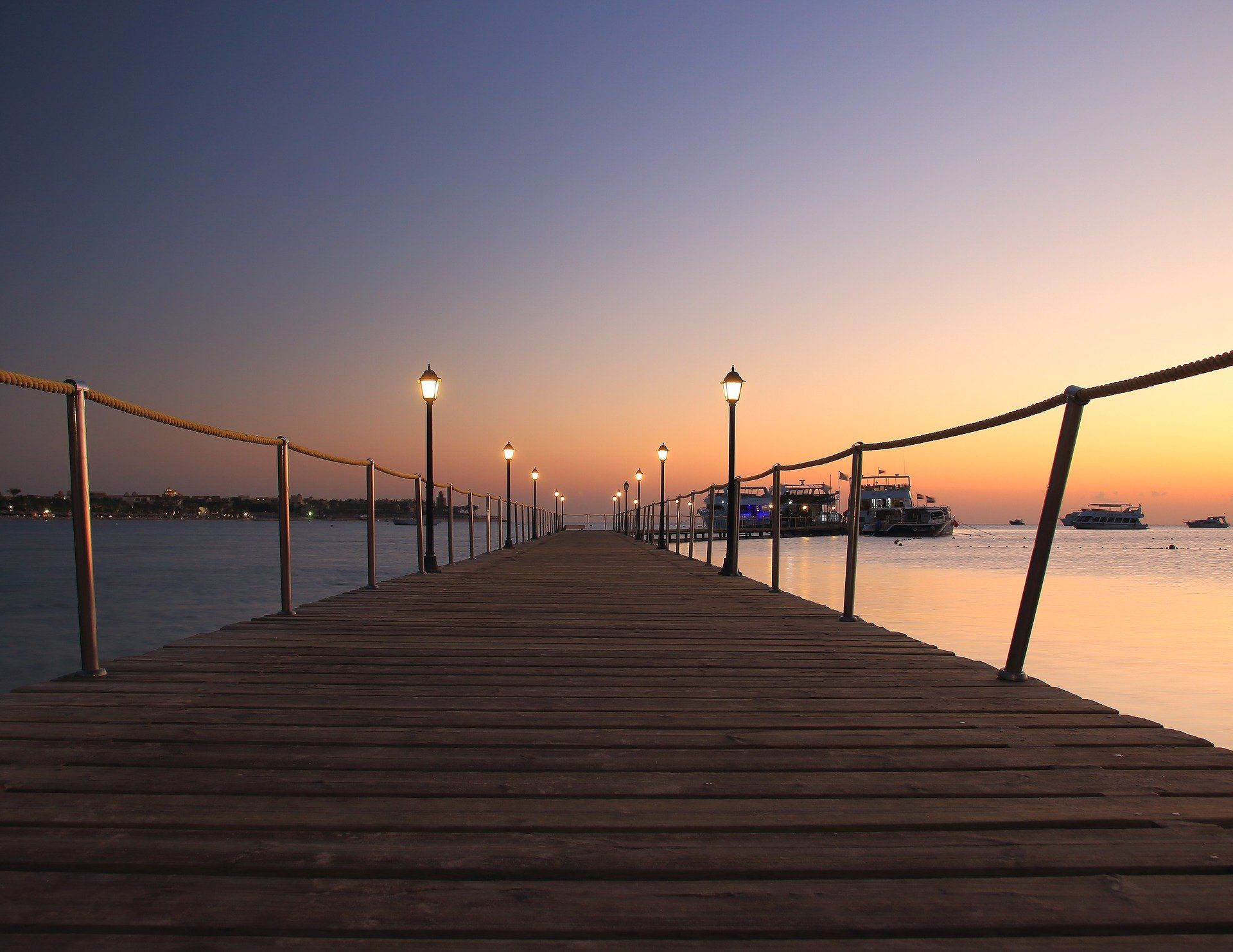 Ein langer Holzsteg, der bei Sonnenuntergang ins Meer führt