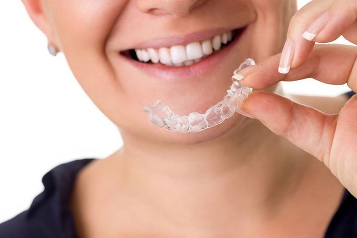 woman holding clear aligners