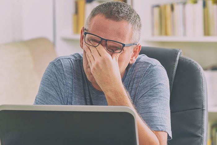 man tired using computer