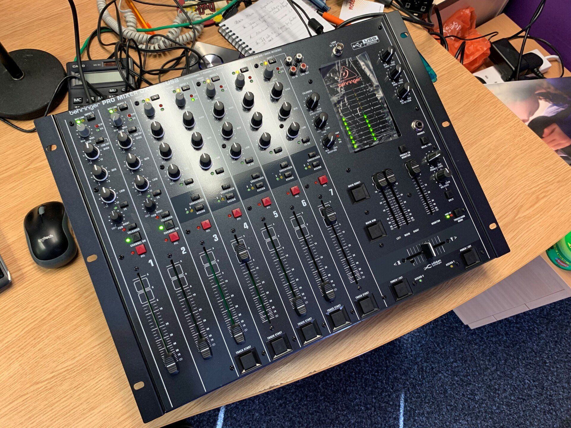 A mixer is sitting on a wooden desk next to a mouse
