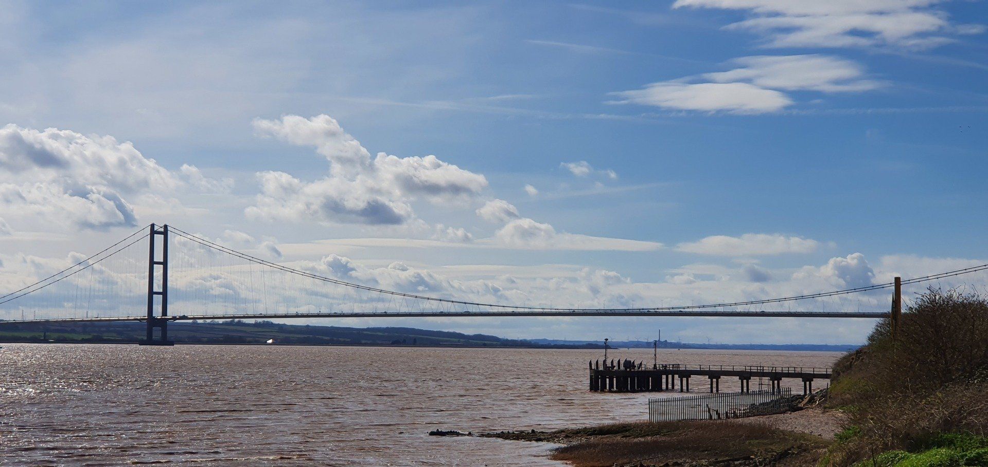 A bridge over a body of water with a blue sky in the background.