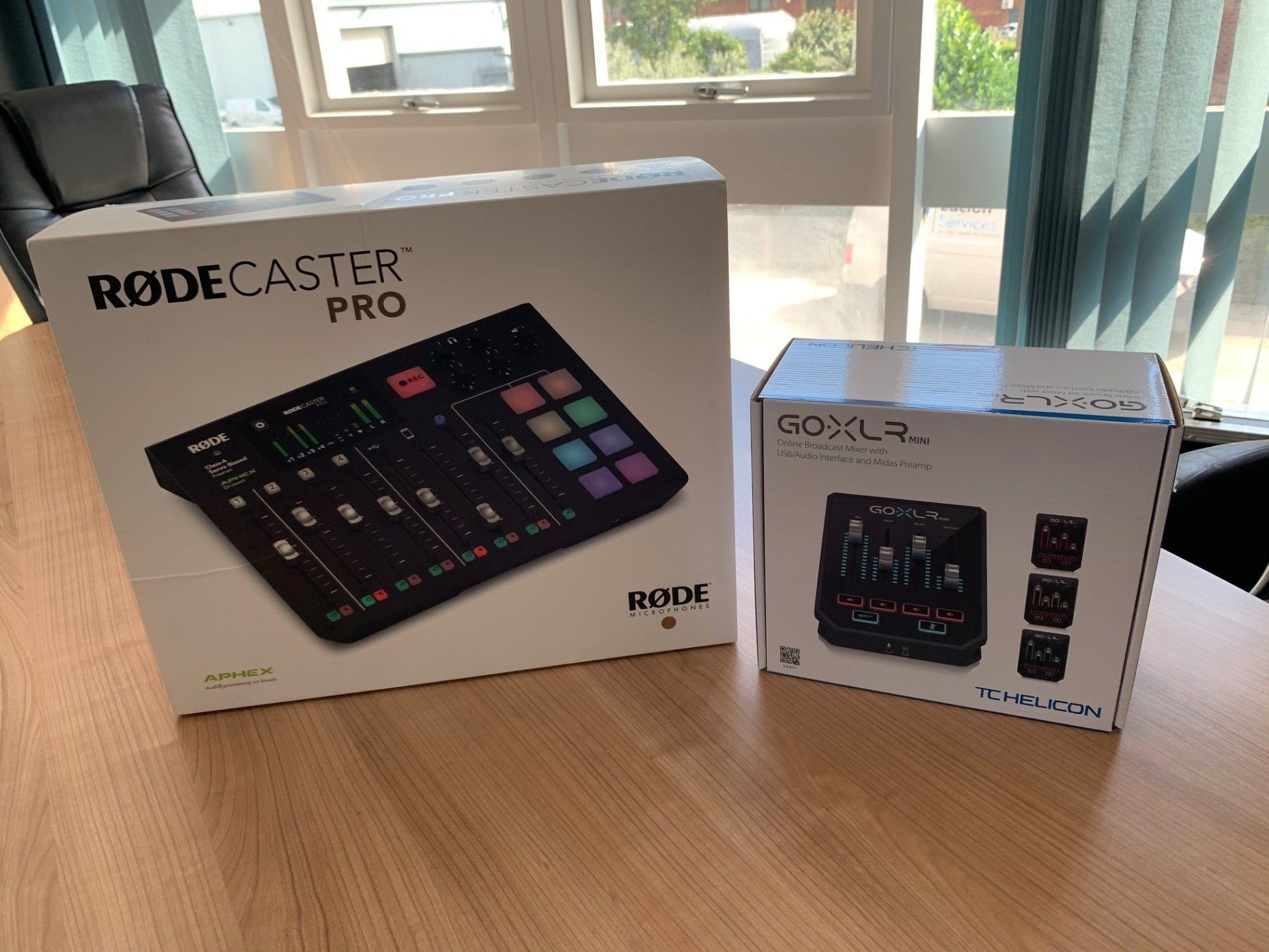 Two boxes of rodecaster pro are sitting on a wooden table.