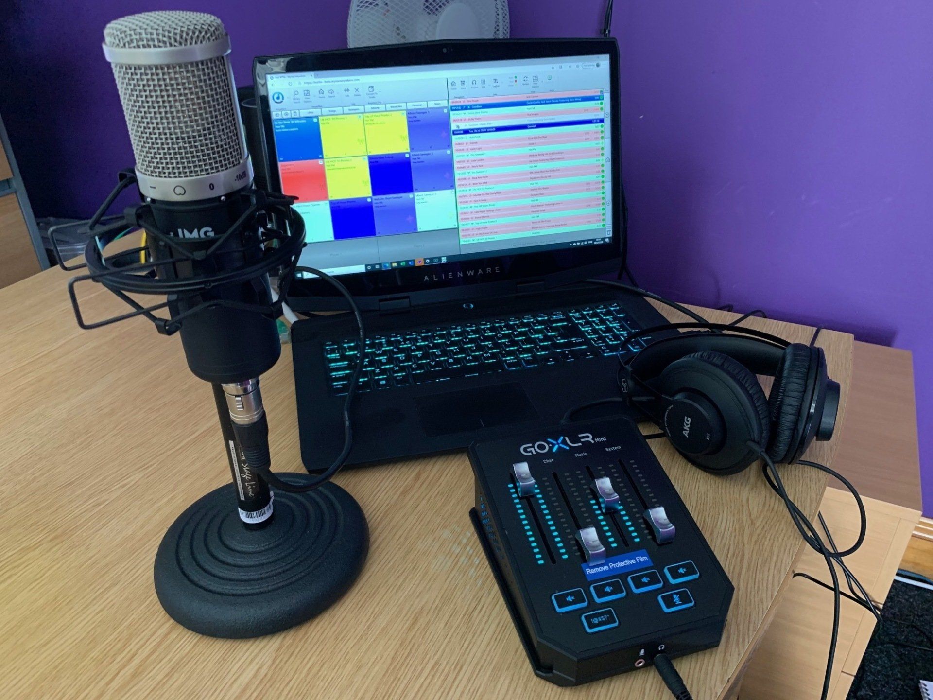 A microphone is sitting next to a laptop and headphones