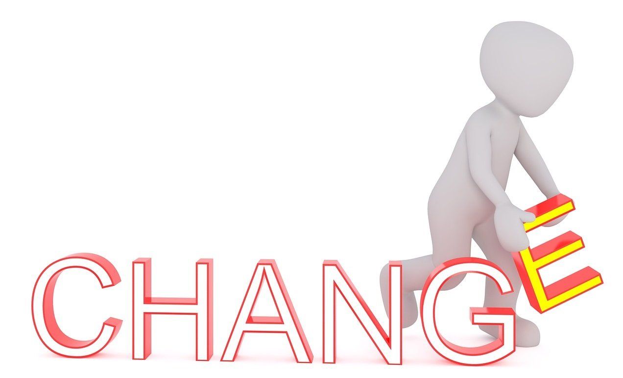 A 3d man is kneeling down next to the word change.