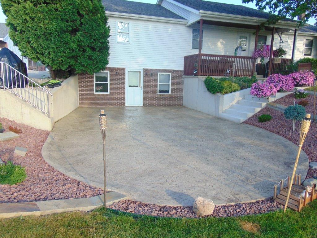 A house with a circular patio and pink flowers in front of it