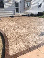 A newly built concrete patio in front of a white house