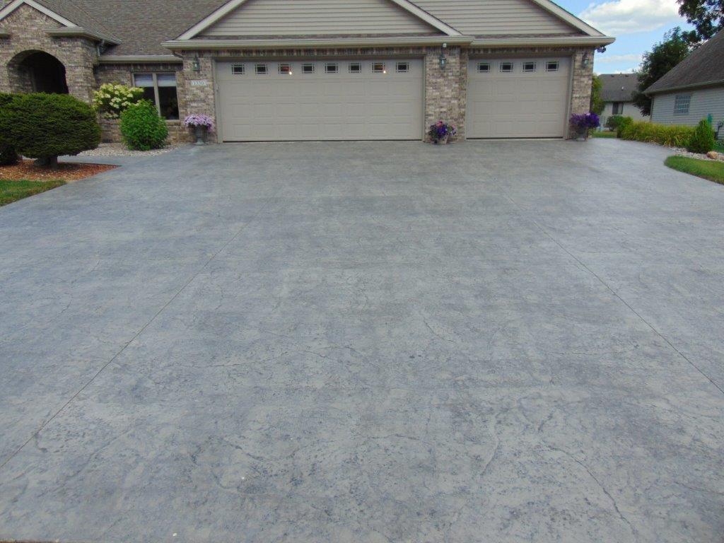A driveway leading to a house with two garage doors