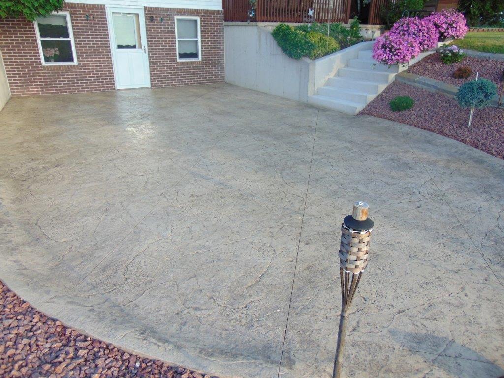 A nice concrete driveway with a torch in front of a house