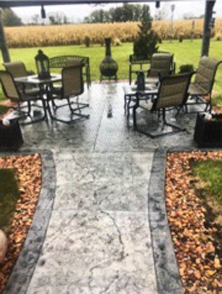 A wide patio with a table and chairs on it