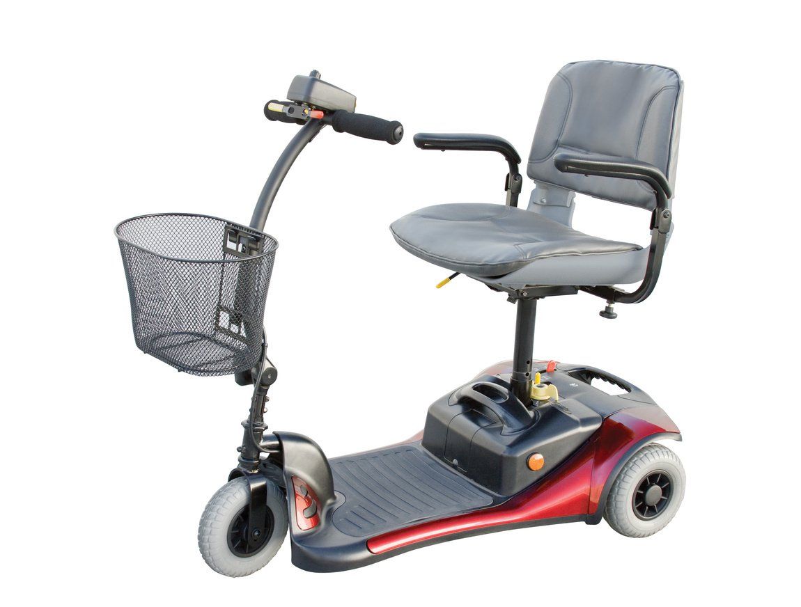 Red and black three-wheeled mobility scooter with a basket and seat on a white background.