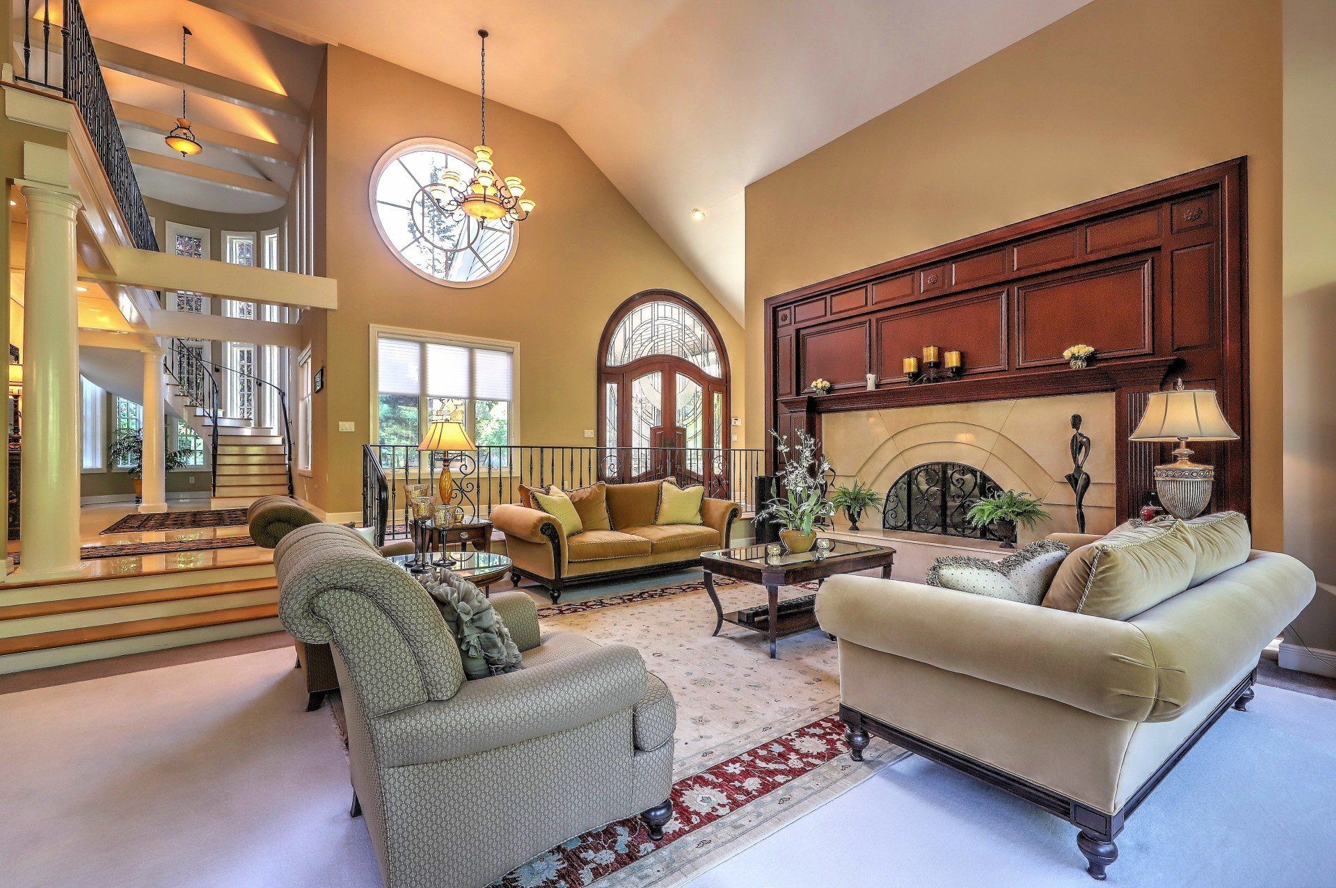 Luxurious living room with fireplace, sofas, and large arched window.