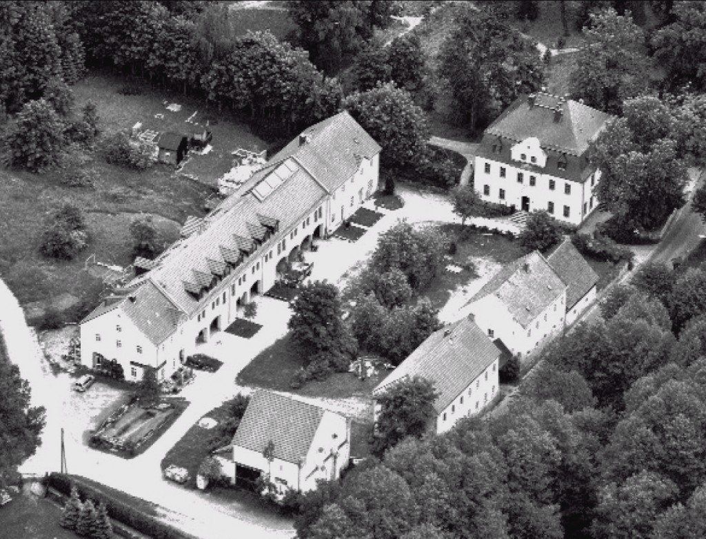 Rittergut Adlershof Umweltzentrum Oberlauterbach Vogtland NUZ - Abb. 14 Luftbild der wiederaufgebauten Gutsanlage aus dem Jahre 2010 (Foto Keller-Thoß). Blick von Nord-West auf den Gutshof, ganz vorn rechts die sanierte westliche Scheunenhäfte, danach parallel der rechtsseitigen etwas verdeckten Treuener Strasse das Remisengebäude mit dem „Kulturboden“ (Sammlung G. Schneider), eine Baulücke, anschließend Stallgebäude mit Wohnung und Scheune. Im Hintergrund das sanierte Herrenhaus mit dem Gutspark. Danach die östliche Hofseite mit dem ehemaligen Gutsverwaltergebäude, dem neuerbauten Natur- und Umweltzentrum (mit Naturherberge) und mit dem Giebelgebäude „Die Hofstub“, dessen Sanierung aus den Abb. 12 und 13 hervorgeht. Rittergut Adlershof Umweltzentrum Oberlauterbach Vogtland NUZ - Abb. 14 Luftbild der wiederaufgebauten Gutsanlage aus dem Jahre 2010 (Foto Keller-Thoß). Blick von Nord-West auf den Gutshof, ganz vorn rechts die sanierte westliche Scheunenhäfte, danach parallel der rechtsseitigen etwas verdeckten Treuener Strasse das Remisengebäude mit dem „Kulturboden“ (Sammlung G. Schneider), eine Baulücke, anschließend Stallgebäude mit Wohnung und Scheune. Im Hintergrund das sanierte Herrenhaus mit dem Gutspark. Danach die östliche Hofseite mit dem ehemaligen Gutsverwaltergebäude, dem neuerbauten Natur- und Umweltzentrum (mit Naturherberge) und mit dem Giebelgebäude „Die Hofstub“, dessen Sanierung aus den Abb. 12 und 13 hervorgeht.