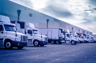 Fleet Vehicles — Trucks Unloading at Warehouse Fleet Vehicles — Trucks Unloading at Warehouse