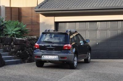 black car in driveway of house with black garage