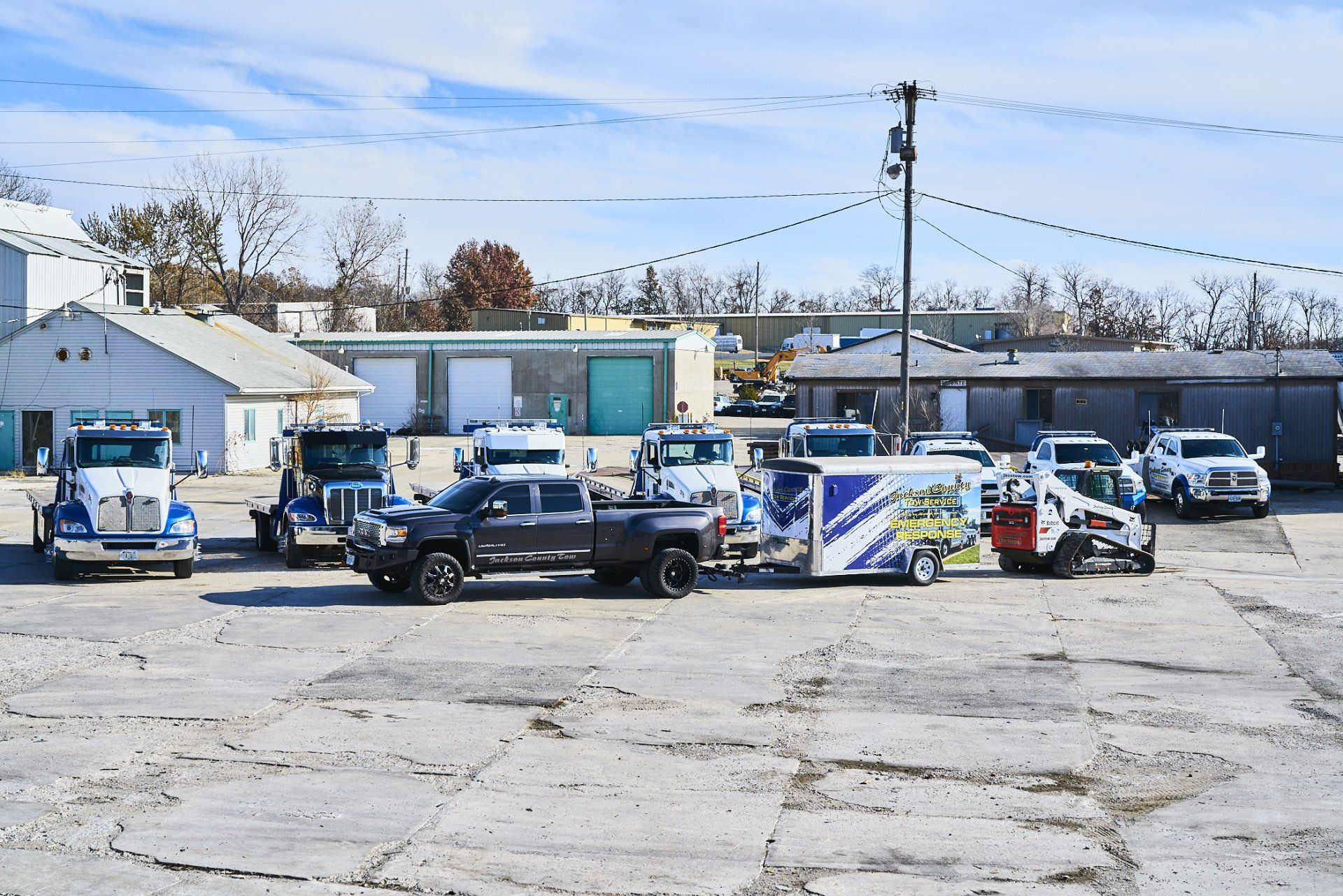 Police vehicles and officers gathered in a parking lot outside low buildings on a clear day