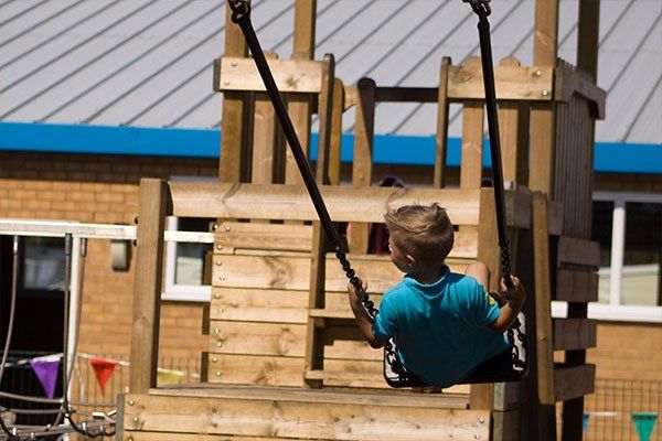 A young visitor playing on the swings at Riverside Holiday Village