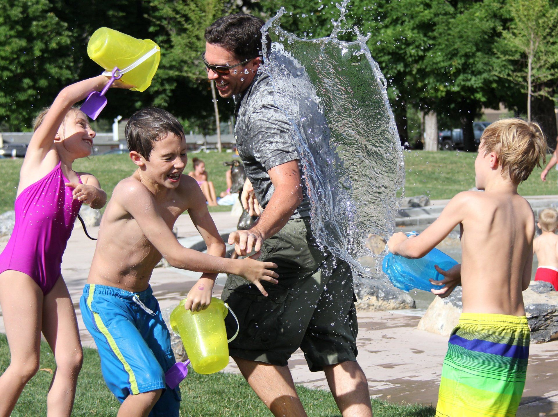 Family having water fight at a holiday park in Somerset.