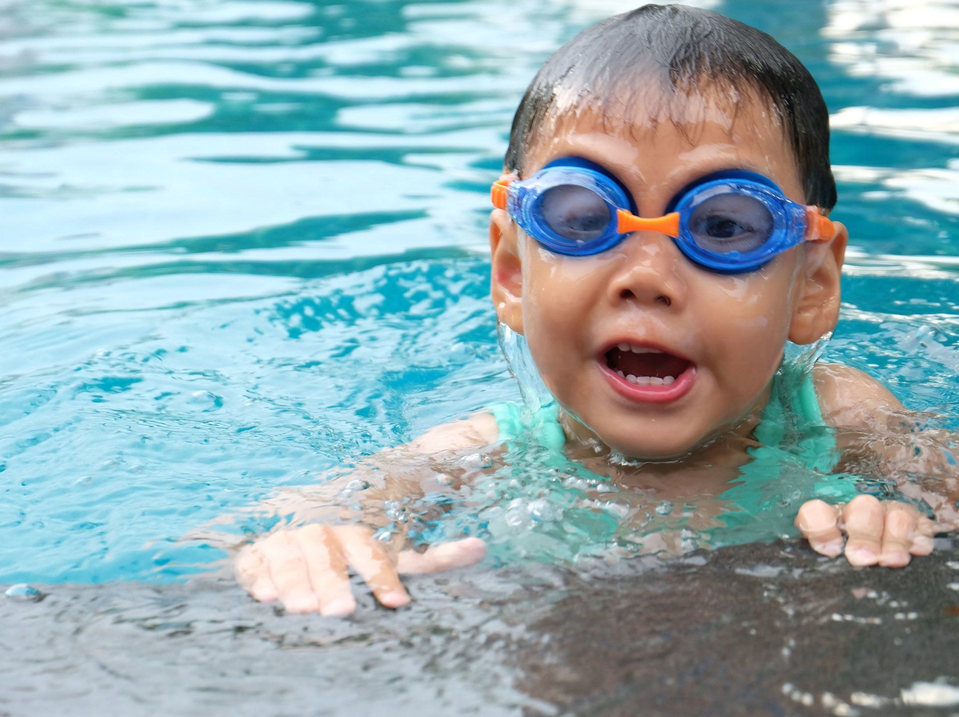 Boy smiling in swimming pool at holiday park in Somerset.