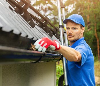 Gutter Installation — Man Cleaning the Gutter in Lititz, PA Gutter Installation — Man Cleaning the Gutter in Lititz, PA