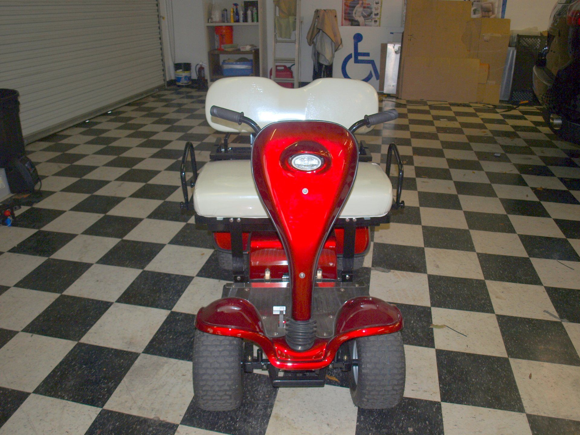 A red and white scooter is parked on a checkered floor