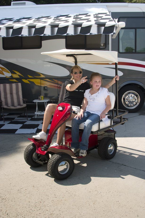 A man and a little girl are riding a golf cart