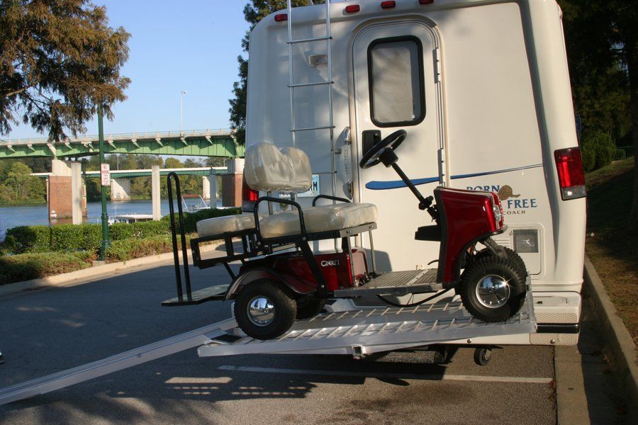A golf cart is attached to the back of a rv