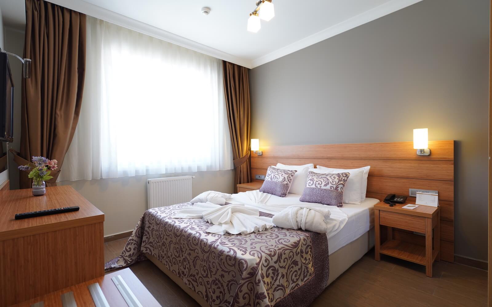Ein Hotelzimmer mit einem Kingsize-Bett und einem Fernseher.