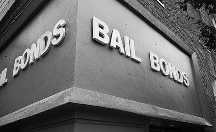 Black and white photograph of a building corner with a sign that reads 