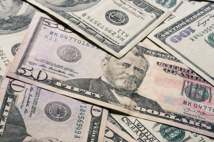 Pile of US currency, including $50 and $100 bills.