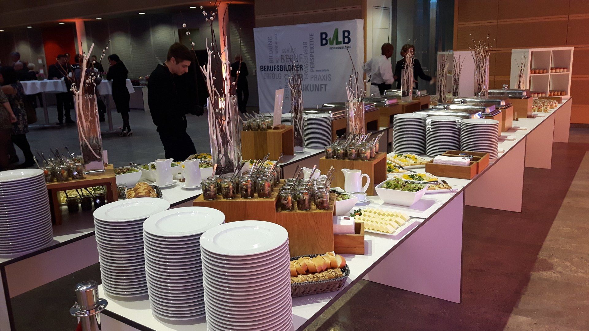 Reichhaltig gedecktes Buffet mit kalten und warmen Speisen, Geschirr.