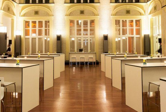 Seminarbestuhlung mit Tischen und Stühlen, daneben runde Stehtische