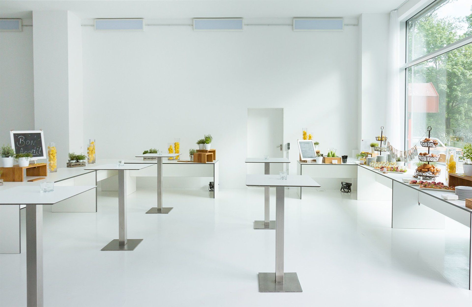 Moderne Stehtische  in Studio 2 Bridge Studios. An den Wänden Frühstücksbuffet