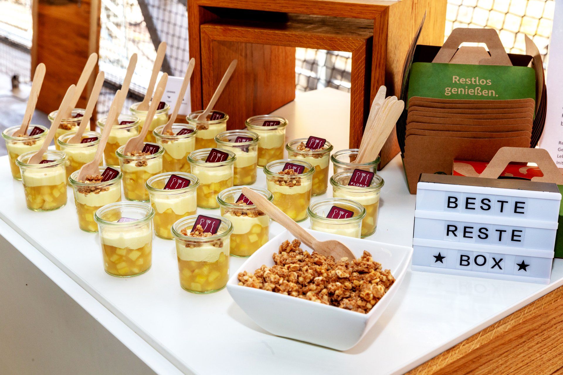 Buffet mit Desserts im Weckglas. Gebrannte Mandeln in weißer Porzellanschüssel. Aufsteller 